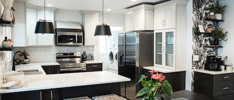 Kitchen with beautiful quartz bar seating, open concept, air fryer oven.