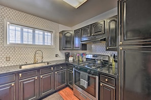 The kitchen is stocked with cooking essentials and some pantry items like oils, spices and more.