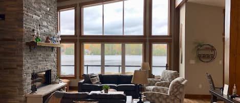 Living room of this modern timber frame lakehouse. Gather around the fireplace.