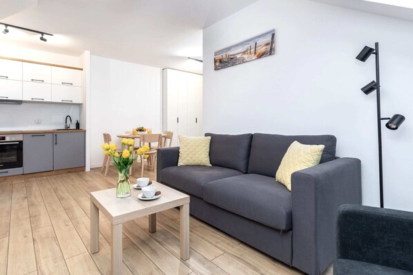A cozy living room with a gray sofa, stylish decor, and a bright atmosphere.

