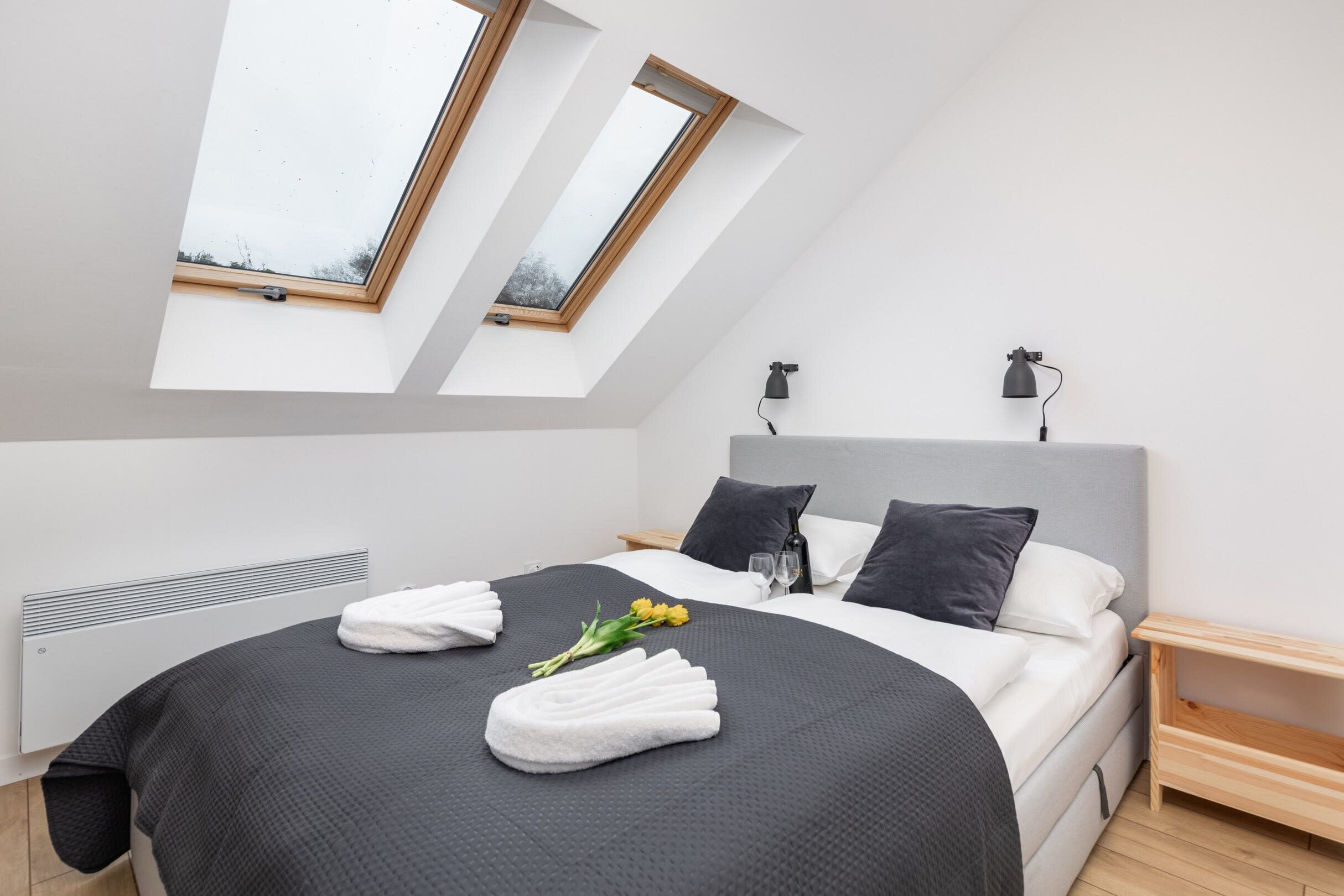 A bedroom with skylight windows, a comfortable double bed, and a cozy ambiance.

