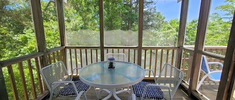 Screen porch with dining table and door to deck