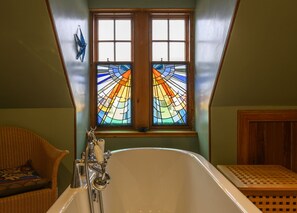 Bright family bathroom with rolltop bath and feature stained glass window