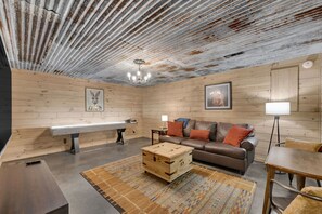 Lower level living room with shuffleboard, Roku TV, board games, and game table.