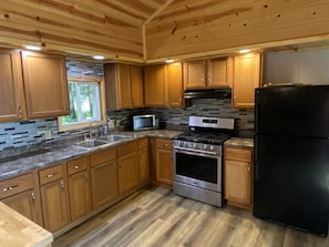 Full size appliances in fully stocked kitchen. 