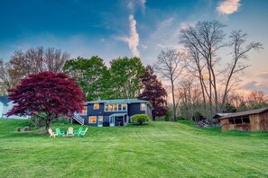 View of backyard from Lake Road.  Firepit, deck, and bbq grill.   Plenty of room for tag football or any other sport!