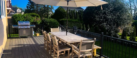 Deck with table, umbrella and Weber grill. Seating for 8.
