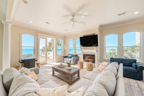 Living room with a large sectional and windows looking toward the water.