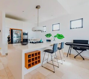 Fully quipped kitchen, built-in wine rack and extra bar table seating.