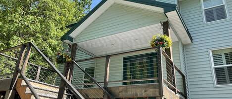 Front porch with rocking chairs and a covered patio to the left. 