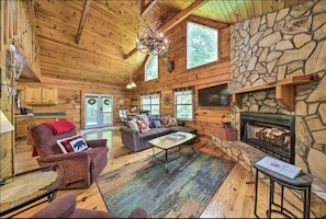 Living room with gas fire place, seating for all leading to kitchen and dining