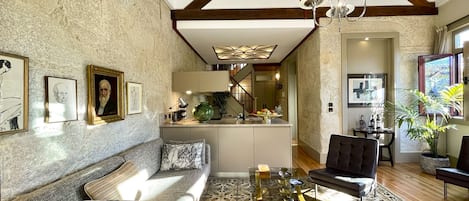 Double height living area with its old wooden structure and opening shutters