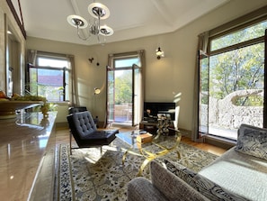 Living area open to the sunny terrace facing the tall trees in the street 