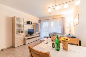 Wohnzimmer mit Esstisch und TV