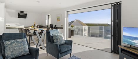 Lounge, dining area and kitchen with a view to the balcony.