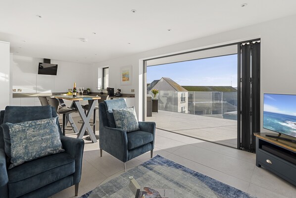 Lounge, dining area and kitchen with a view to the balcony.