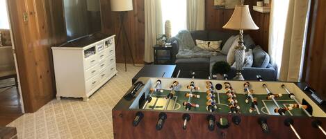 Multi purpose room has foosball table, games, large TV, sectional & desk