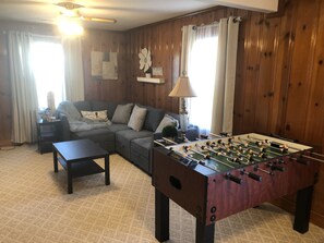 Multi purpose room has foosball table, games, large TV, sectional & desk
