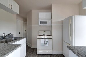 Full kitchen with stove, microwave, and refrigerator.