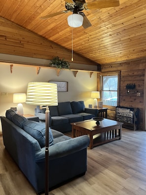Cozy open family gathering area with two couches, a rocking chair and a TV.