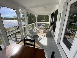 Fully screened-in front porch that is just steps from the water.