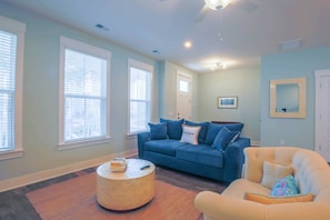 The lower level features a living room, access to the front porch, dining table and kitchen.