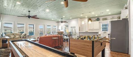 Open concept living, kitchen, dining with foosball and shuffle board.