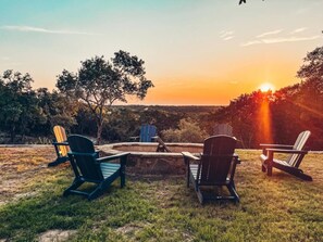 The backyard offers a large fire pit with comfy Adirondack chairs for cozy evenings by the fire. Dive into the pool or relax in the hot tub while taking in the breathtaking views of the Pedernales River Valley.