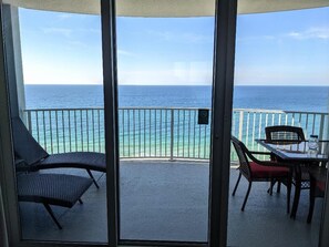 Oversized balcony with lounge chairs and dining for four people