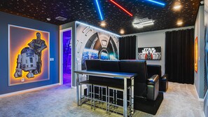 Immersive home theater with sci-fi decor, starry ceiling, and themed lighting