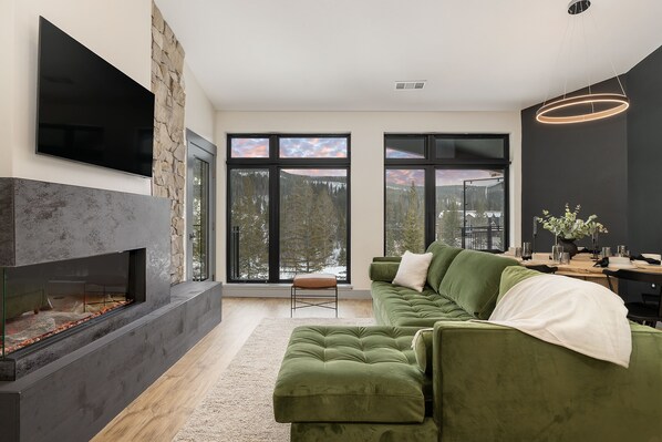 The main room, featuring huge windows, fireplace,, smart TV, and Queen sleeper.