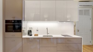 Modern kitchenette with a stove, oven, coffee machine, toaster etc. There's also an AC machine!