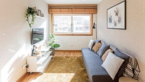 Cozy and modernly decorated living room, with lots of natural light and a flat-screen TV for your entertainment #charming #stunning #lovelystay #airbnbporto