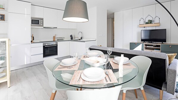 Overview of the main area of the house. Bright, with modern decoration, a dining area for four, a kitchenette and a comfortable couch, with AC and a TV for your entertainment #superb #bright #lovelystay #airbnbporto