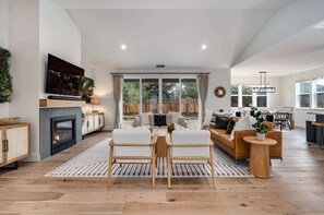 Living area with a 65 inch smart TV, SONOS surround sound system, gas fire place, board games. 