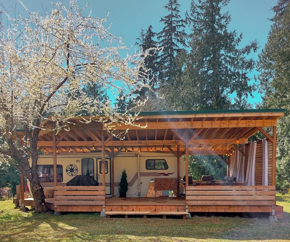 View of the Glamping Trailer during Spring when the plum tree is in bloom.