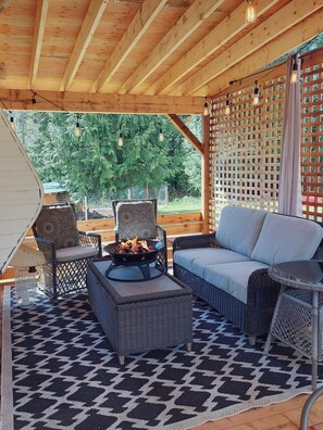 Covered deck with cozy seating and propane fire table.