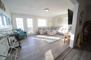 A modern living room with a sectional sofa, rug, coffee table, and TV, perfect for relaxing and unwinding after a long day.