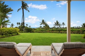 View of the expansive lawn from the lower lanai loungers.