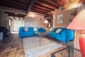 Living room with large corner sofa - Large TV set in period stone fireplace - Wood burner (wood supplied).
