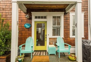 Back porch, where you`ll find a gas grill and a couple of Adirondacks.