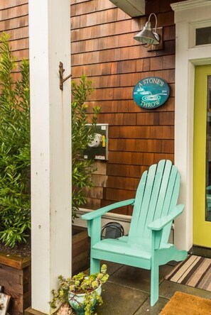 Back porch, where you`ll find a gas grill and a couple of Adirondacks.