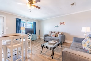 Aesthetically decorated living room. Top floor, with over looking balcony, connected to a full kitchen and dining room table.