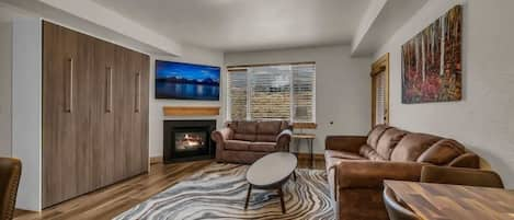 The view over the stylish open kitchen/dining/living room, this space is filled with natural light and comfortable seating options perfect for your group to relax together.