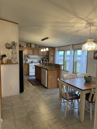 Spacious open kitchen with bar stools and farm table that seats six.