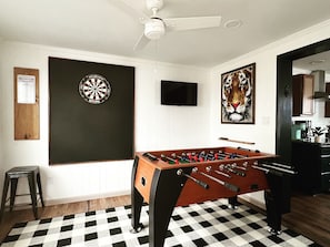 Game Room with regulation dart board, full-sized foosball table, smart TV.