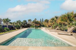 Luxury pool for your St. Augustine vacation with swim up bar, sun shelf, loungers, gas fireplace, and hot tub.