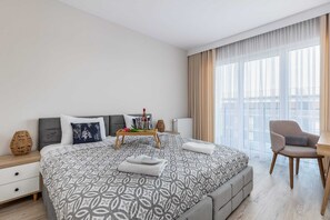 A spacious bedroom featuring a comfortable bed and ample natural light.

