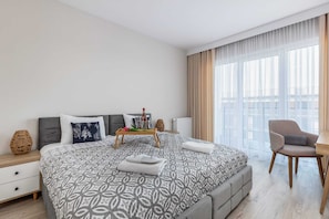 A spacious bedroom featuring a comfortable bed and ample natural light.