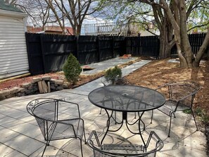 Backyard: A table with four chairs provides seating for up to four people.